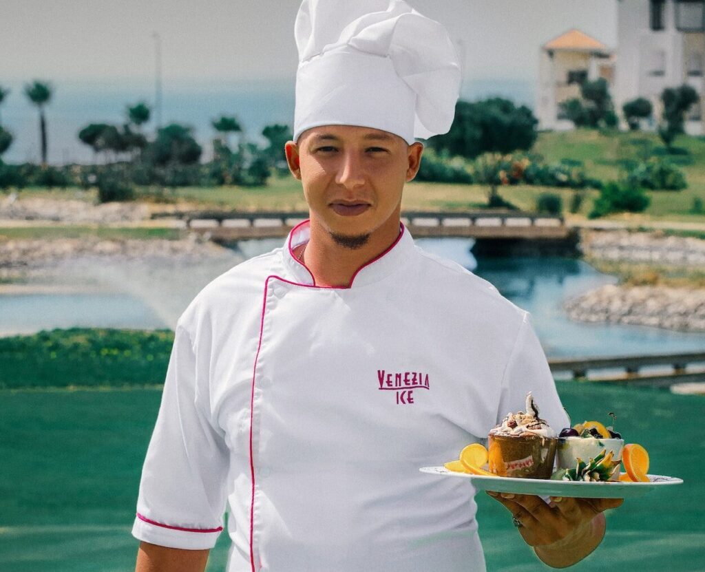 woman in white chef uniform holding green plate with food