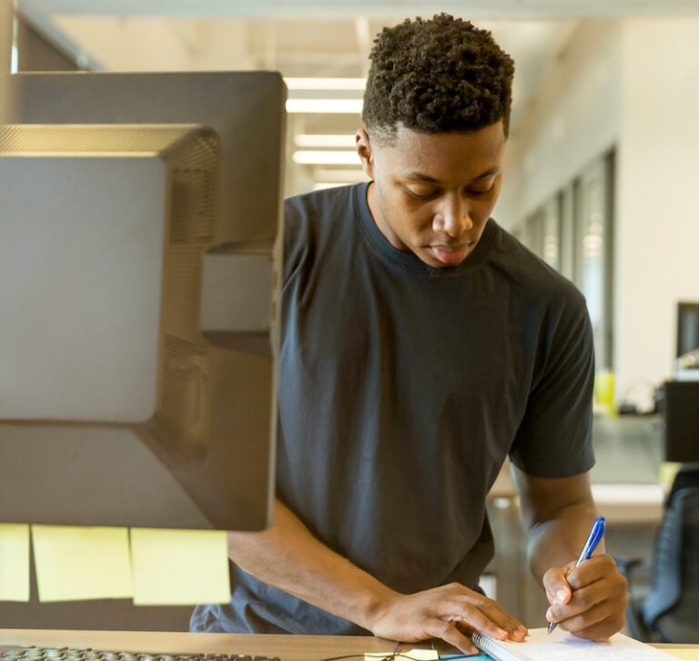 man writing on white paper