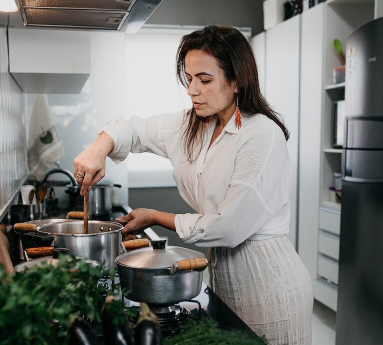 woman in white long sleeve shirt holding green vegetable